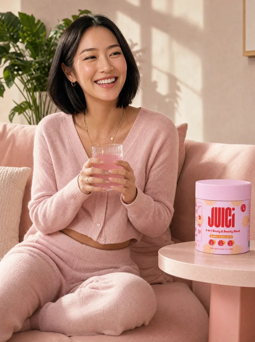 Woman relaxing on a pink sofa with a glass of JUICi, a tub of JUICi on the side table